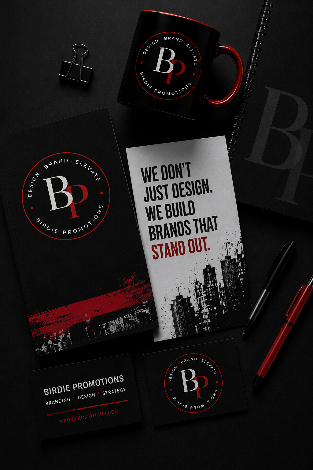 Black and red branding workspace featuring Birdie Promotions logo, business cards, notebook, and creative marketing materials